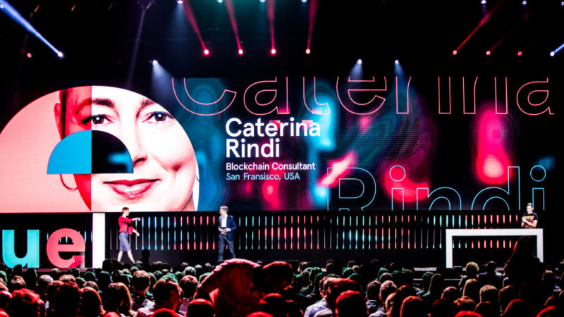 Caterina Rindi walking on stage as she is announced as a speaker.